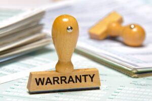 Wooden stamp with the word "Warranty" on it, symbolizing a roof warranty.